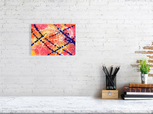 A painting with a pinkz yellow and orange background with splatters of dark blue and white 