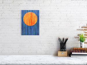 An image of a sunrise composed of strips of coloured mount board collaged onto a board